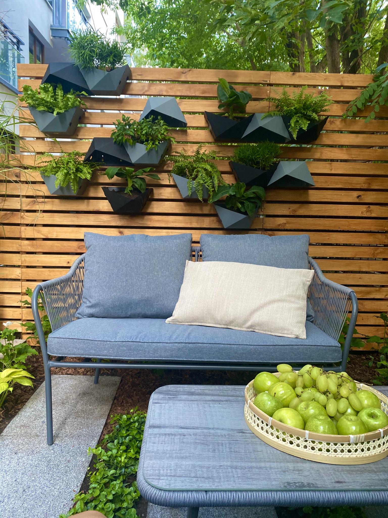 "Wymarzone ogrody": wygodna kanapa na tle wiszących donic